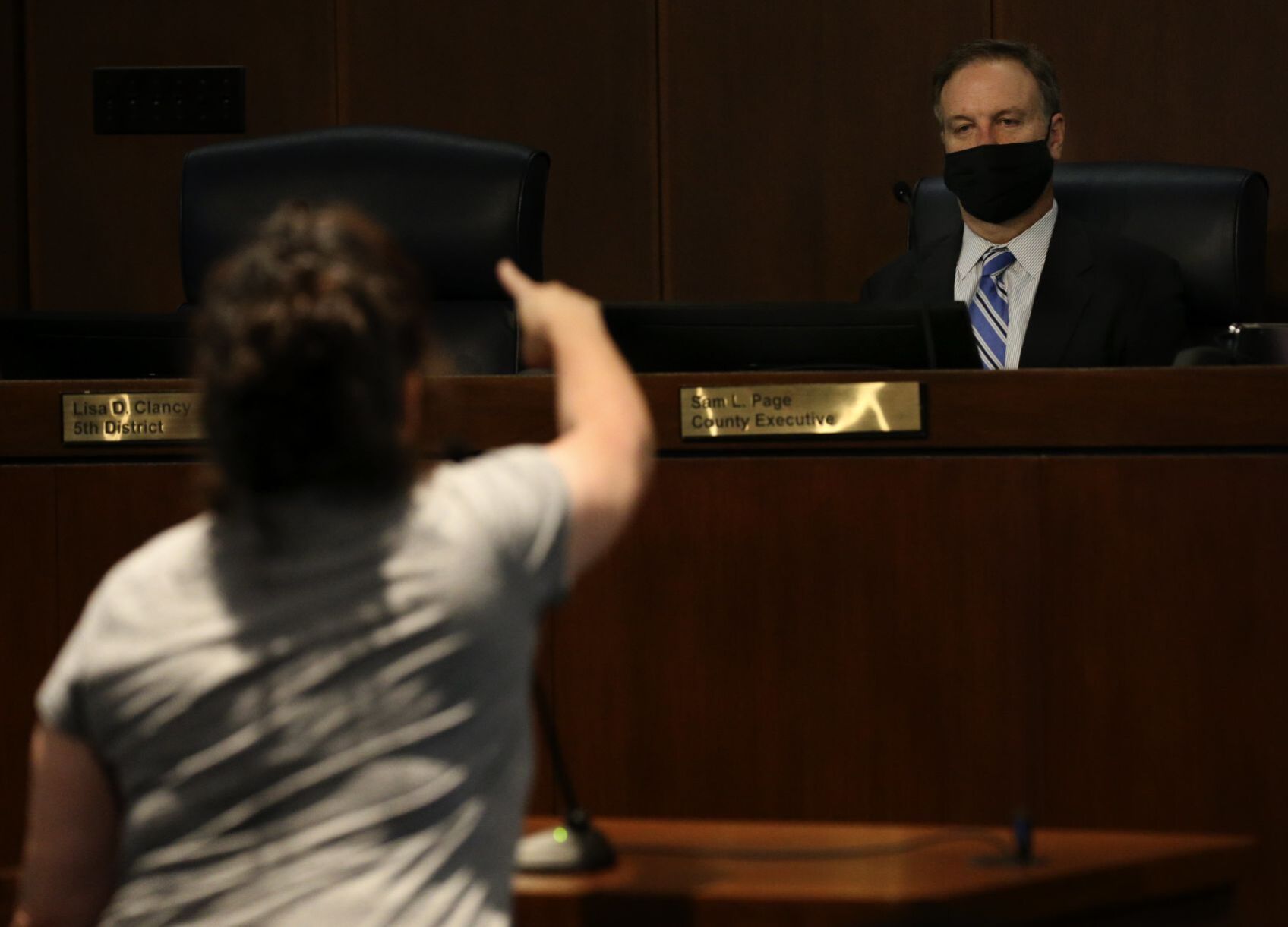 St. Louis County Executive Sam Page listens to Angelina Isaac criticize the mask mandate